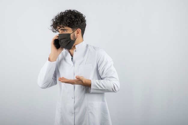 Jonge dokter heeft een interessant gesprek met de telefoon.