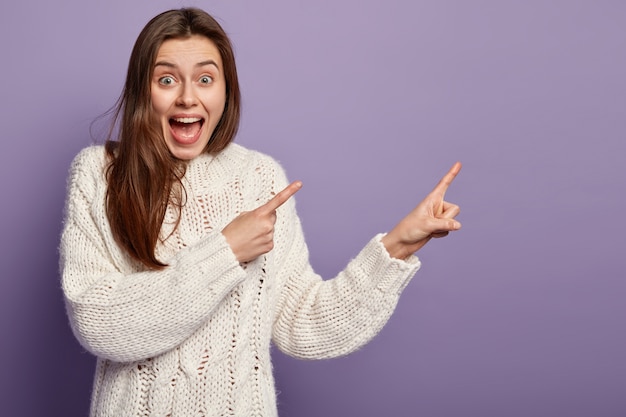 Jonge donkerbruine vrouw die witte sweater draagt