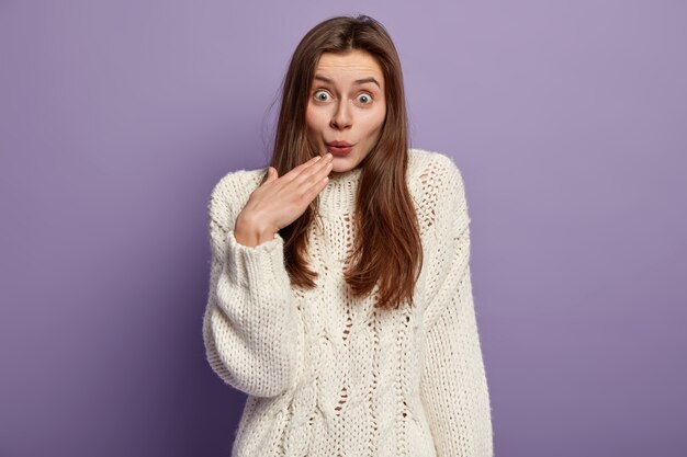 Jonge donkerbruine vrouw die witte sweater draagt