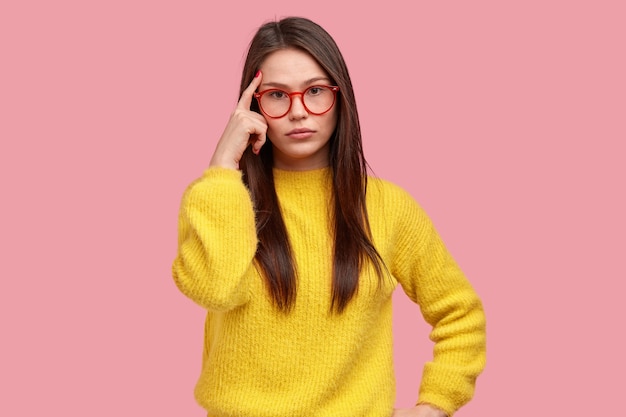 Jonge donkerbruine vrouw in gele sweater