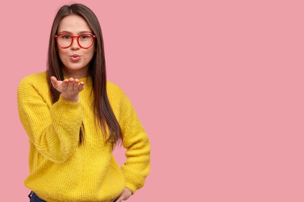 Jonge donkerbruine vrouw in gele sweater