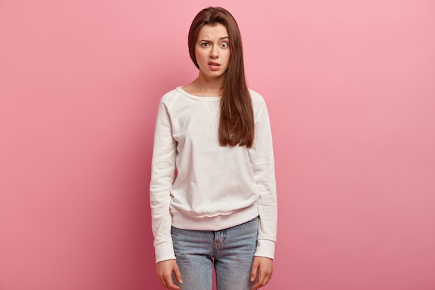 Jonge donkerbruine vrouw in jeans en sweater