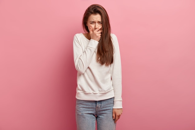 Jonge donkerbruine vrouw in jeans en sweater