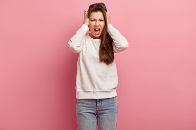 Jonge donkerbruine vrouw in jeans en sweater