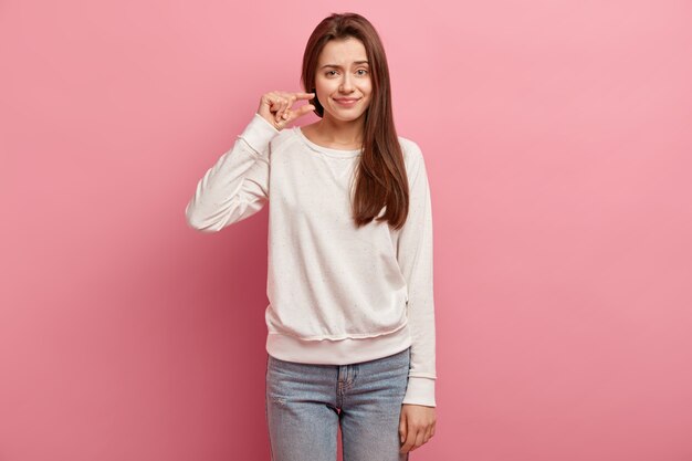 Jonge donkerbruine vrouw in jeans en sweater