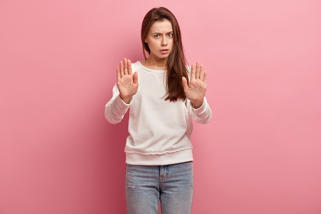 Jonge donkerbruine vrouw in jeans en sweater