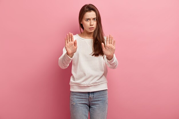 Jonge donkerbruine vrouw in jeans en sweater