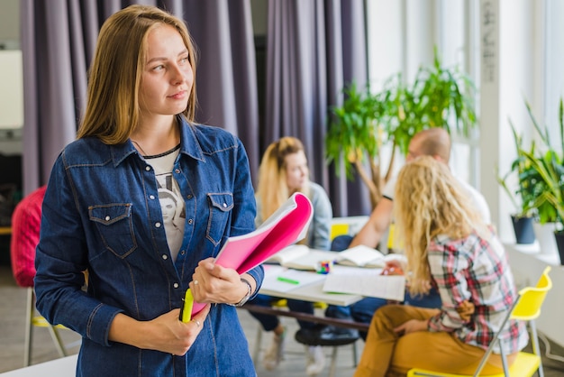 Jonge droomende vrouw poseren met een handboek