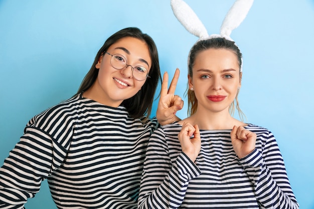 Jonge emotionele vrouwen die op gradiënt blauwe muur worden geïsoleerd. concept van menselijke emoties, gezichtsuitdrukking, vriendschap, advertentie. mooie kaukasische vrouwelijke modellen in vrijetijdskleding.