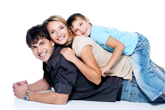 Jonge en gelukkige familie met kind poseren op witte ruimte