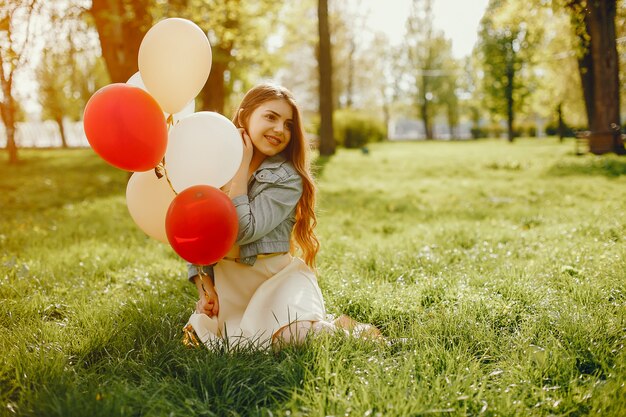 jonge en heldere meisjes lopen in het park van de zomer met ballonnen