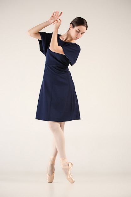 Jonge en ongelooflijk mooie ballerina danst in een blauwe studio