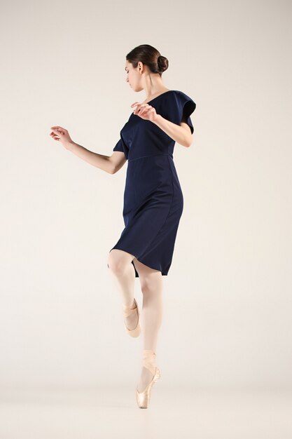 Jonge en ongelooflijk mooie ballerina danst in een blauwe studio