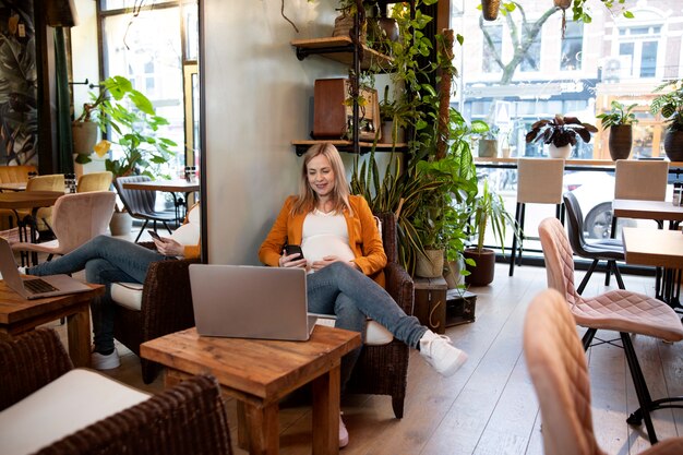 Jonge en zwangere vrouw aan het werk