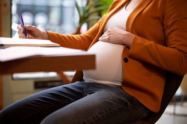 Jonge en zwangere vrouw aan het werk