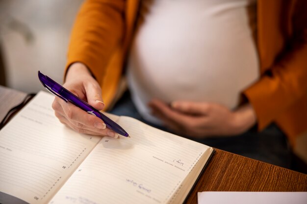 Jonge en zwangere vrouw aan het werk