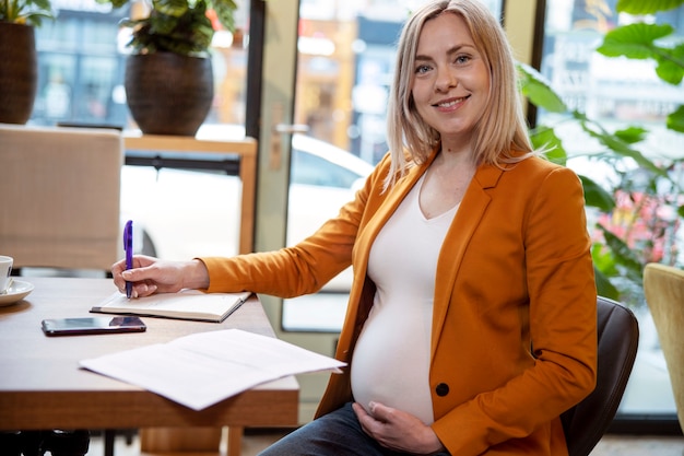 Jonge en zwangere vrouw aan het werk