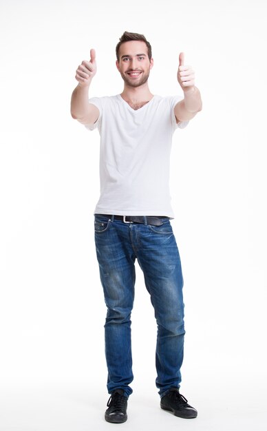 Jonge gelukkig knappe man met duimen omhoog teken in casuals in volle groei - geïsoleerd op wit
