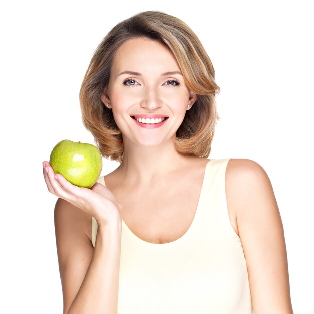 Jonge gelukkig lachende vrouw met groene appel geïsoleerd op wit.