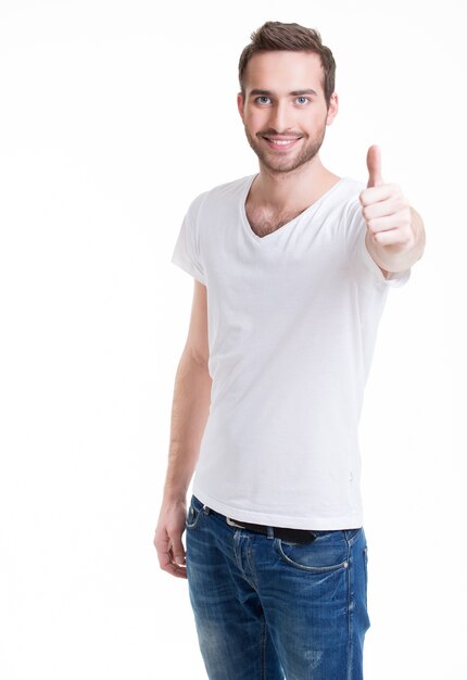 Jonge gelukkig man met duimen omhoog teken in casuals geïsoleerd op een witte achtergrond.