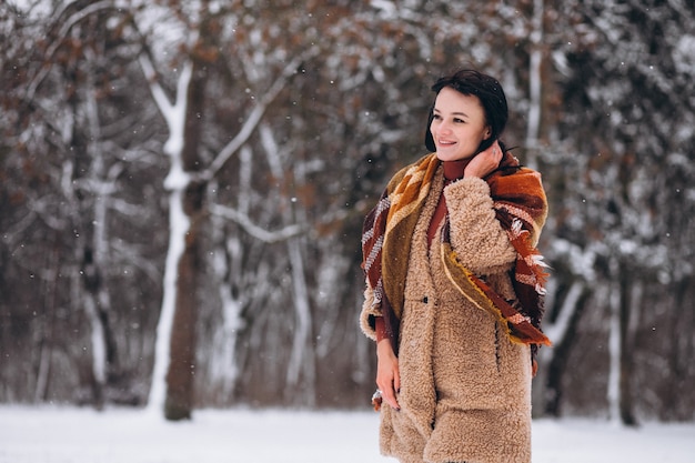 Jonge gelukkige vrouw in warme doeken in een winter park