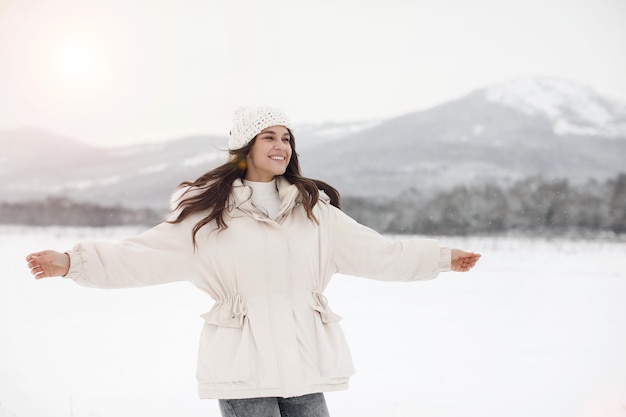 jonge gelukkige vrouw in winterjas in sneeuw buiten