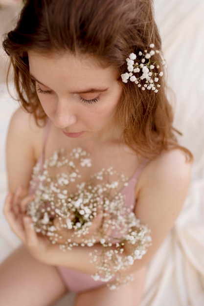 Jonge gelukkige vrouw poseren met bloemen