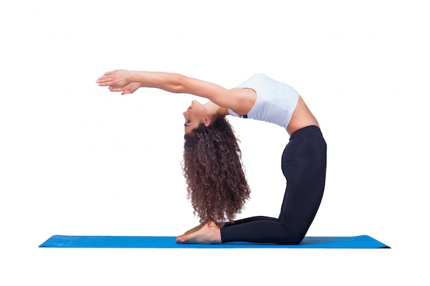 Gratis foto jonge geschikte vrouw die yogaoefeningen doet.