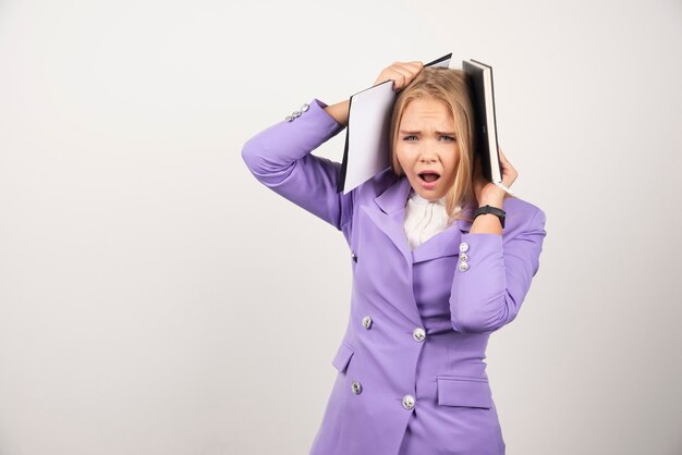 Jonge geschokte vrouw met tablet op wit.