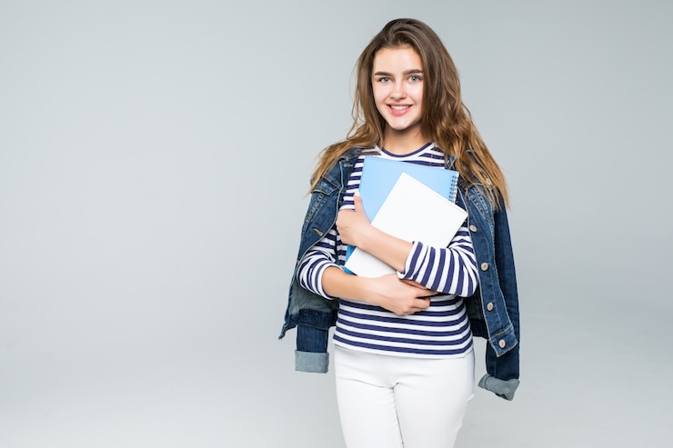 Gratis Foto jonge glimlachende studentenvrouw over witte achtergrond