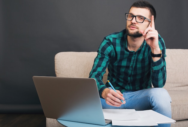 Jonge hipster knappe bebaarde man zittend op de Bank thuis