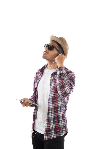 Jonge hipster man in oortelefoons met smartphone die op th