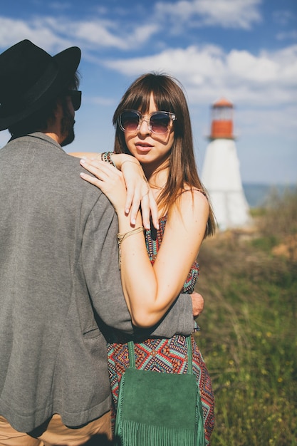 Jonge hipster paar indie stijl verliefd wandelen in platteland, vuurtoren op achtergrond