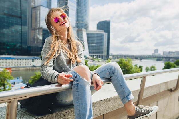 Jonge hipster vrouw plezier in straat luisteren naar muziek op de koptelefoon