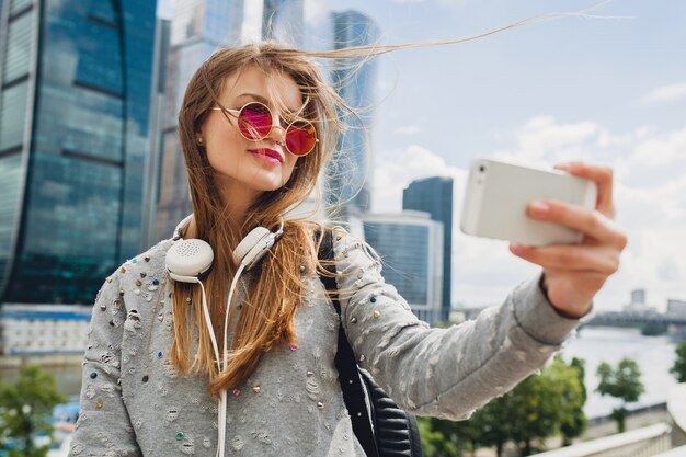 Jonge hipster vrouw plezier in straat, roze zonnebril dragen