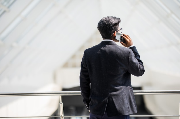 Jonge Indiase zakenman op een telefoon aan de telefoon