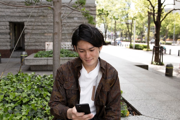 Jonge japanse man die tijd alleen buitenshuis doorbrengt