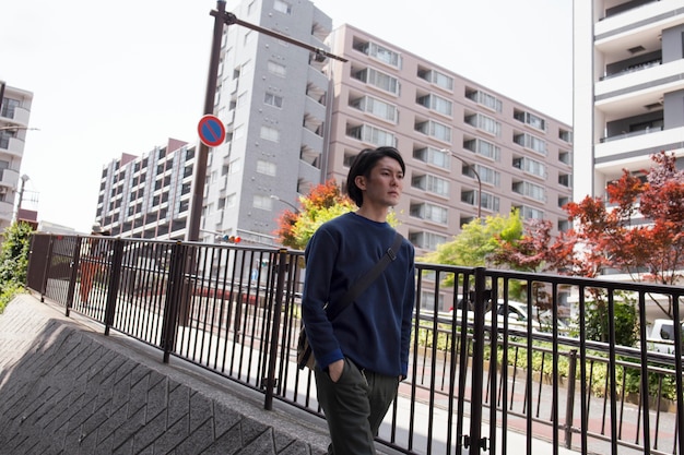 Jonge Japanse man in een blauwe trui in de stad