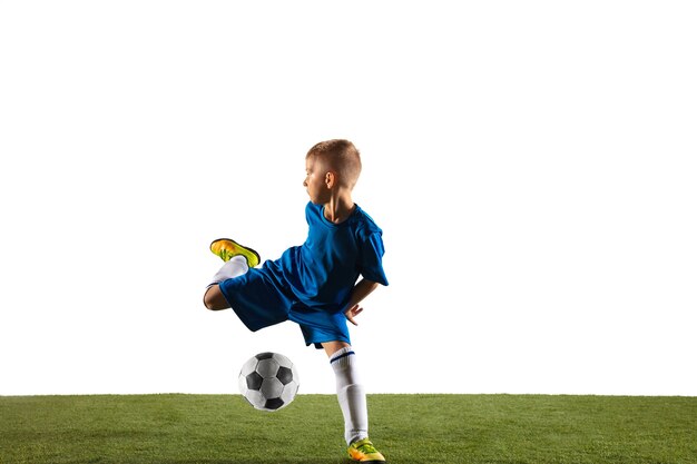 Jonge jongen als voetbal of voetbalspeler in sportkleding die een schijnbeweging of een schop met de bal maakt voor een doel op witte studioachtergrond. Fit spelende jongen in actie, beweging, beweging bij spel.