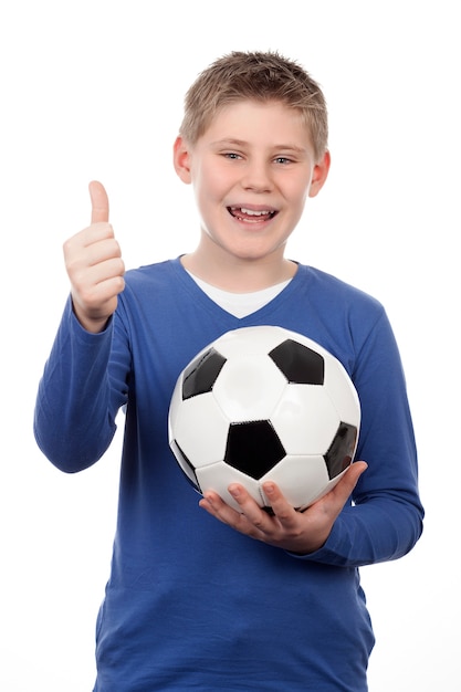 Jonge jongen die een voetbalbal op witte ruimte houdt