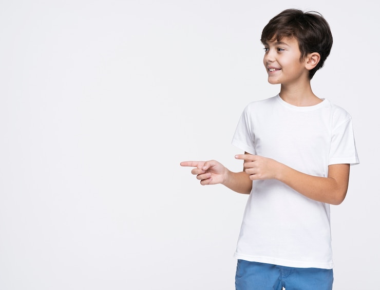 Gratis Foto jonge jongen die met exemplaarruimte richt