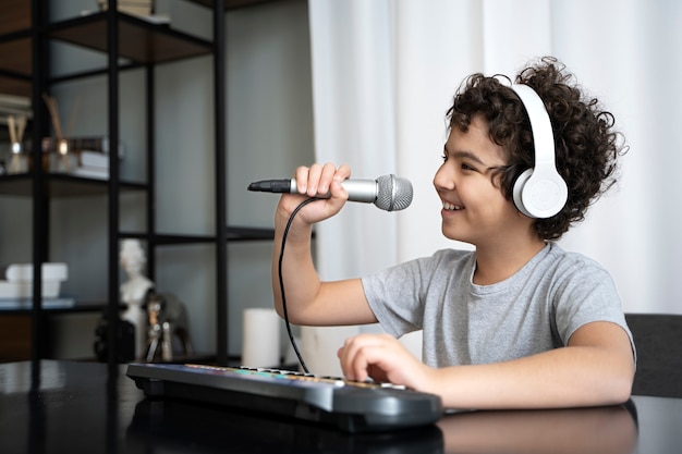 Gratis foto jonge jongen die muziek speelt