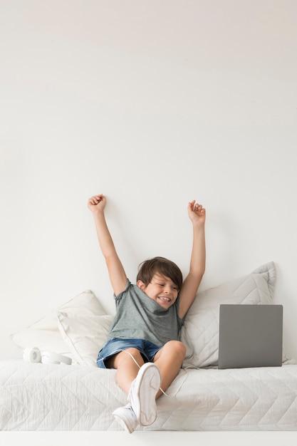 Jonge jongen die op laptop kijkt