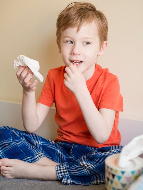 Jonge jongen die zijn neus blaast