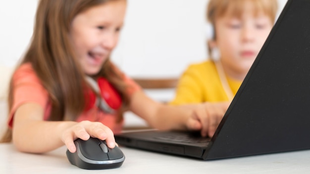 Jonge jongen en meisje die laptop en muis met behulp van