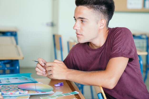 Jonge jongen met schoolmateriaal in de klas