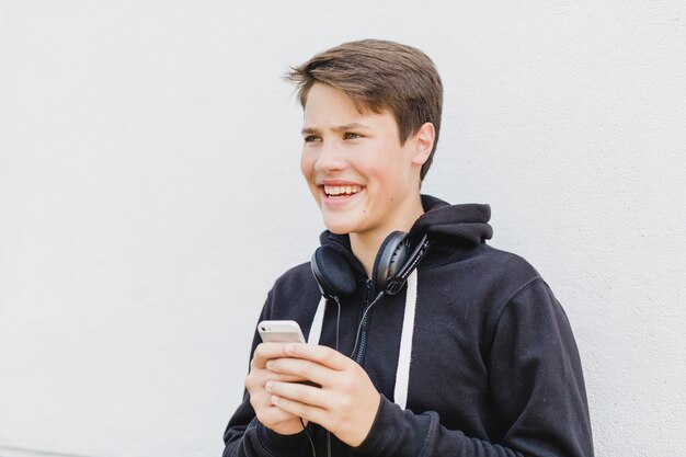 Jonge jongen met telefoon op straat