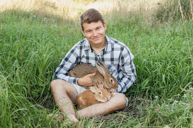 Jonge jongen op boerderij met konijnen