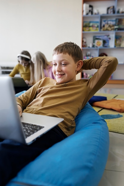 Jonge jongen werkt en gebruikt zijn laptop