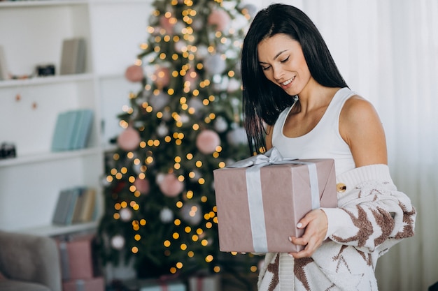 Jonge Kerstmis van de vrouwenholding huidig door Kerstmisboom